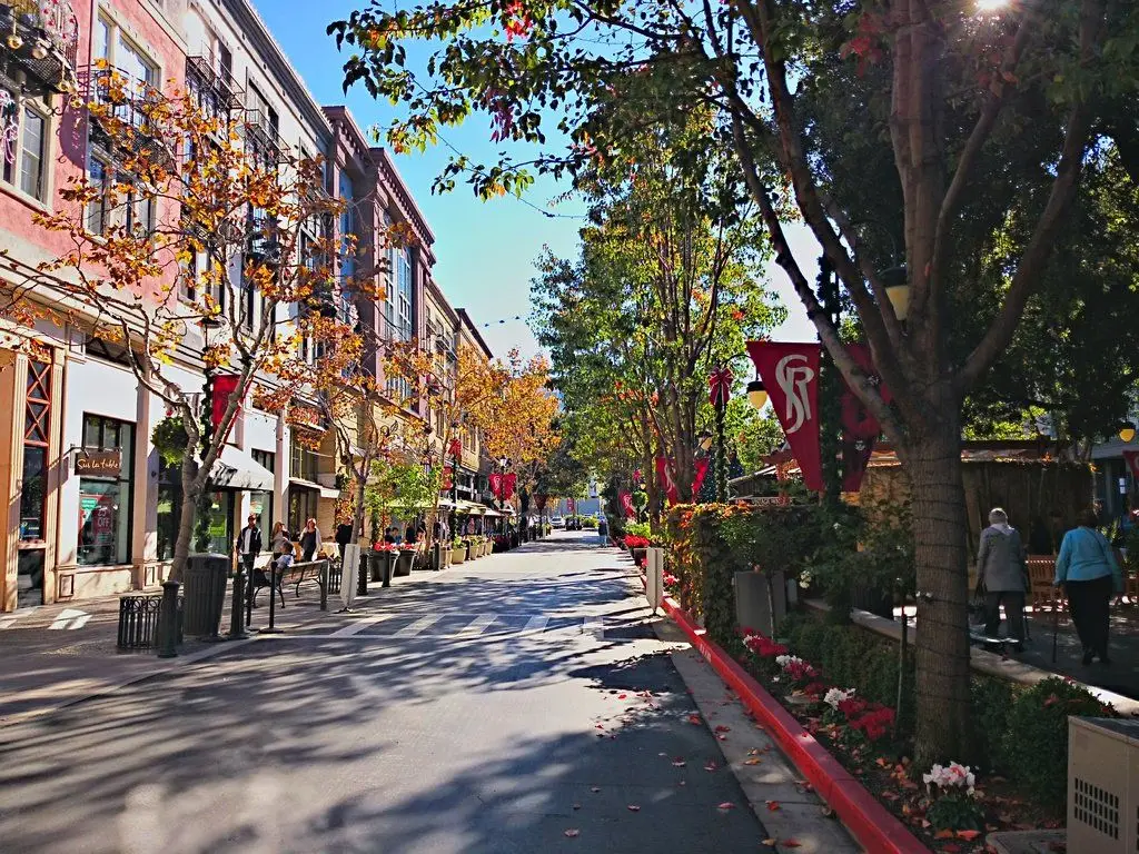 A street with many trees and buildings on the side