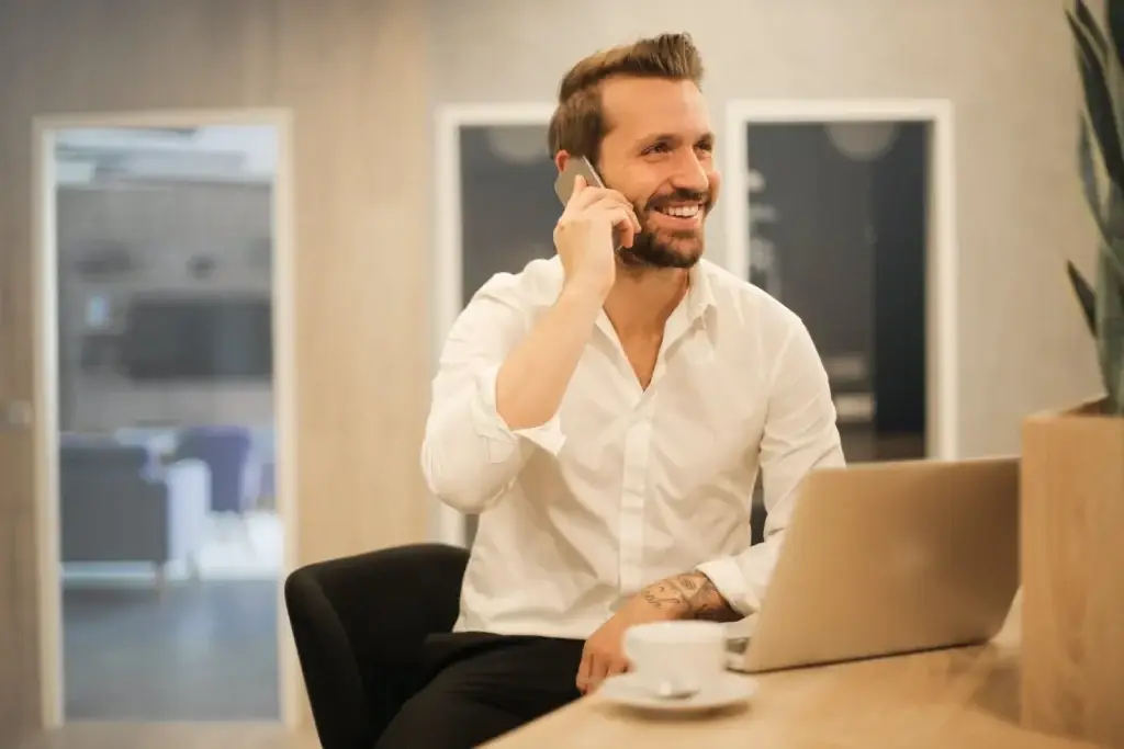 A man sitting at a table talking on the phone.