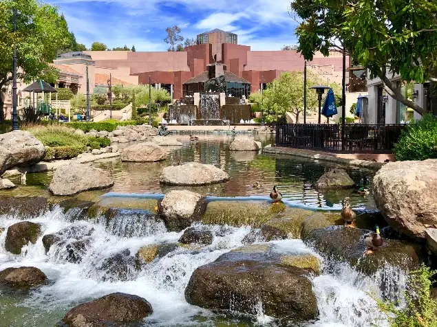 A view of a waterfall and people swimming in it.